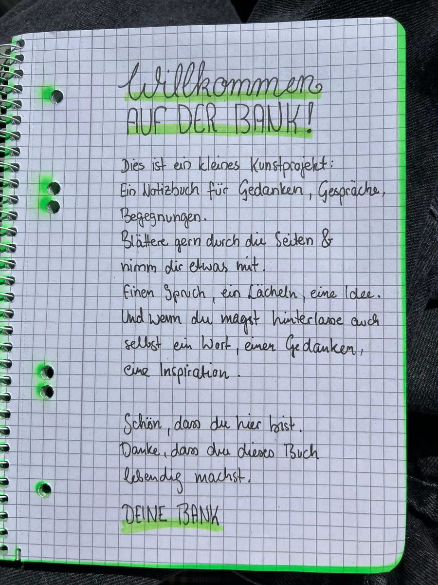Handgeschriebene erste Seite des Gästebuchs: „Willkommen auf der Bank!“ mit einer kurzen Einladung, zu blättern und etwas zu hinterlassen.